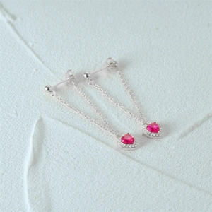 Close-up of S925 silver drop earrings featuring pink heart stones and pavé crystals