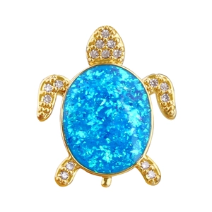 Détail d'un pendentif tortue de mer dorée avec opale bleue et cristaux étincelants