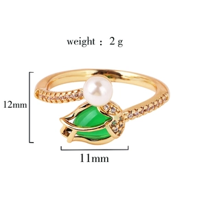 Detail view of gold-tone ring with green teardrop stone and white pearl measurements