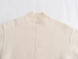 Close-up of cream white stand-up collar and textured boucle knit fabric on casual sweater