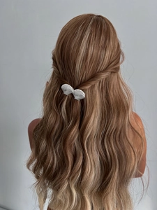 Vue détaillée d'une pince à cheveux coquillage argentée sur une coiffure ondulée