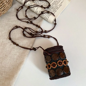 Close-up of coconut shell beads and sunflower embroidery on ethnic crossbody bag
