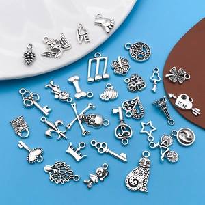 Detailed assortment of silver alloy charms for DIY jewelry making on clean background