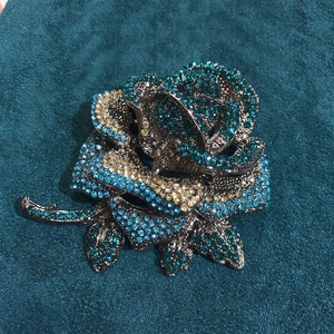Detailed view of luxury rose brooch featuring blue and champagne crystal rhinestones