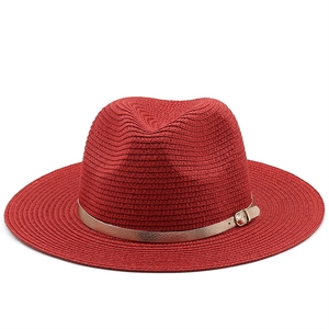 Detail view of the fine woven red straw fedora with gold faux leather belt and metal buckle