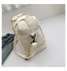 Detail view of star-quilted fitness bag with shoe compartment and adjustable strap