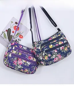 Detail of floral pattern crossbody bags with multiple zippers and adjustable straps