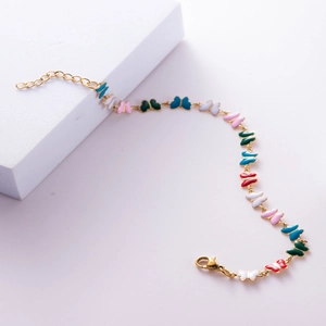 Detailed macro view of gold-plated chain with colorful enamel butterfly charms and lobster clasp