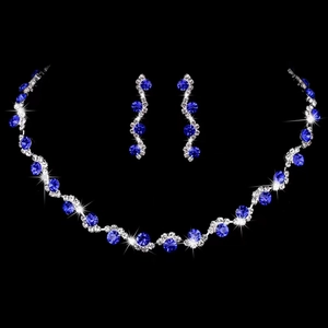 Close-up of bridal jewelry set with blue gemstones and silver rhinestones on black background