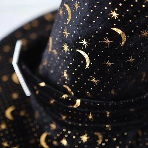 Close-up of black velvet fabric with gold foil moon and stars for wizard hats