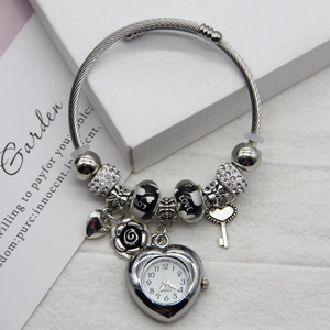 Detail of silver beaded bracelet watch with heart-shaped dial, rose and key charms