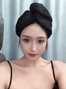 Close-up of a premium black satin hair towel wrap worn by a model for quick hair drying