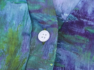 Detailansicht aus Chiffon mit Ölgemälde-Druck und weißem Knopf in Nahaufnahme