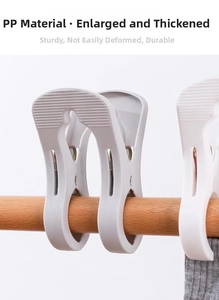 Detail of large white plastic quilt clip with strong spring on a wooden pole