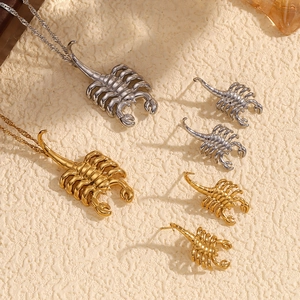 Detail view of 18K gold and silver scorpion pendant necklaces and stud earrings set