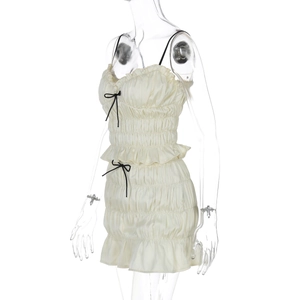 Detail view of beige ruffled chiffon set featuring camisole top and pleated mini skirt