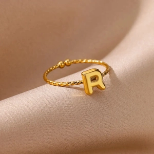 Detailed close-up of 18k gold plated twist ring featuring a bold letter R on silk