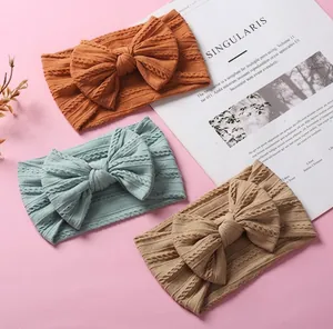 Detailed cable knit texture on baby nylon headbands with large decorative bows