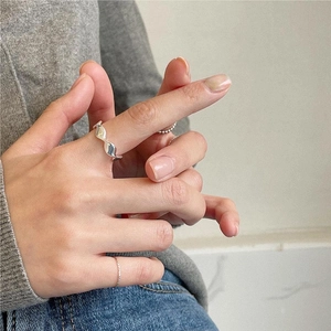 Close-up of stacked 925 sterling silver rings with wave texture on a female hand