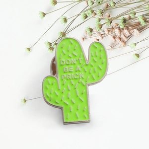 Green enamel cactus brooch with 'DON'T BE A PRICK' text and silver metal edges