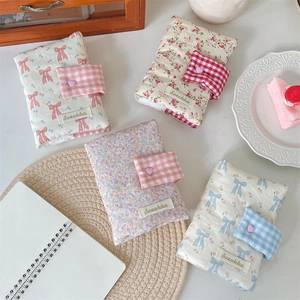 Floral fabric notebook cover with cute bow and heart snap button on white table