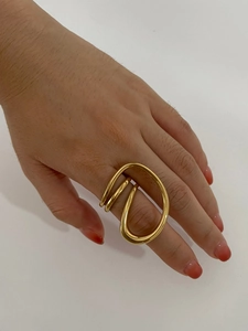 Macro shot of gold-plated geometric multi-layer wrapped open ring on model finger