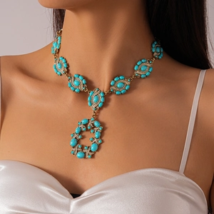 Close-up of model wearing a vintage gold necklace with blue turquoise and diamonds