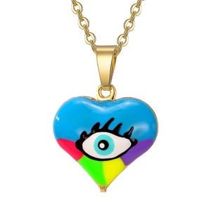Close-up of heart pendant with colorful enamel and evil eye detail on gold chain