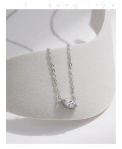 Detail of s925 sterling silver necklace featuring a marquise cut diamond pendant on stone