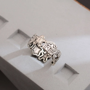 Silver vintage gingerbread man open ring with Christmas house motifs on a textured base
