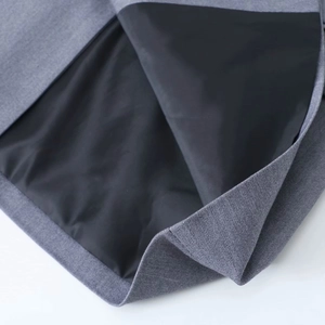 Détail du tissu en tweed gris et doublure noire montrant la qualité de la couture