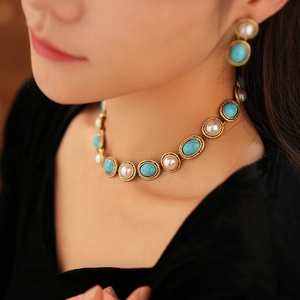 Detail of vintage gold necklace and earrings set with green turquoise and white pearls