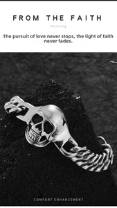 Macro close-up of punk skull pendant with rugged Cuban chain on dark volcanic rock