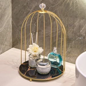Golden birdcage vanity organizer with marble base for luxurious bathroom storage