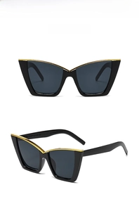 Detail view of black cat-eye sunglasses with golden V-shaped metal trim on frame