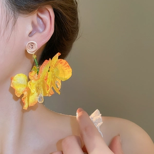 Close-up of floral tassel earring with beige rose and yellow gradient fabric petals