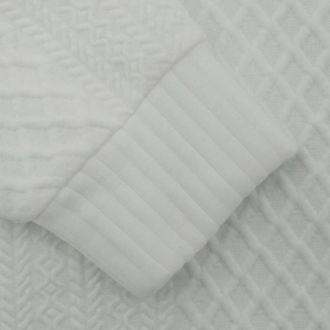 Macro detail of white men's knitted sweatshirt showing ribbed cuff and jacquard texture