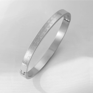Silver stainless steel bangle with engraved wave patterns and secure clasp closure