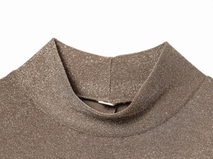 Dettaglio dell'abito in maglia metallica color caffè con texture luccicante e collo alto