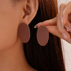 Close-up of a large matte mocha oval stud earring with elegant gold metallic edging