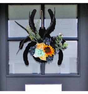 Détail de couronne d'araignée d'Halloween avec tournesols et roses artificielles