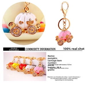 Detail of pumpkin carriage keychain with shiny rhinestones and colorful oil drip finish
