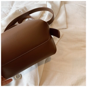 Close-up detail of the brown leather texture and stitching on the vintage bucket bag