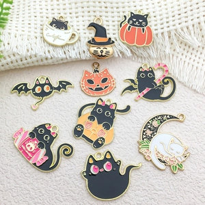 Detailed view of ten Halloween black cat metal charms with orange pumpkins and bats