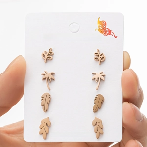 Detail of four pairs of rose gold stainless steel plant-shaped earrings on a card