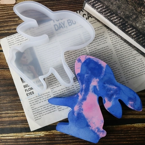 Detail of translucent silicone Easter bunny mold next to finished colorful resin vase