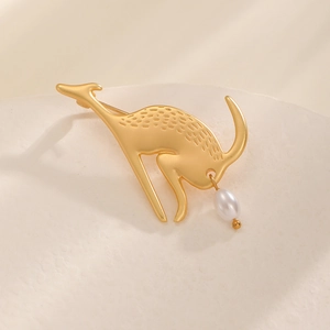 Gros plan sur la broche kangourou dorée mate avec pendentif perle blanche ovale