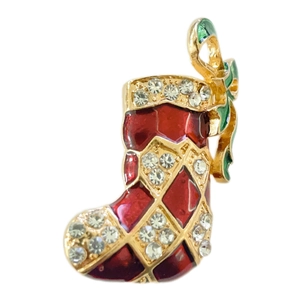 Detail view of a Christmas stocking brooch with red enamel, gold alloy, and crystals