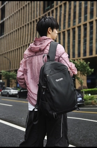 Black nylon travel backpack shown on person featuring side pockets and BAYORE logo