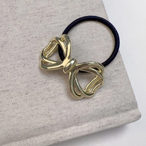 Elegant hollow metal bow hair tie in gold finish for high-end ponytail hairstyles